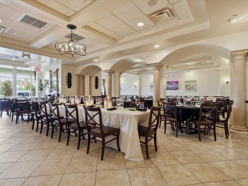Ciao Italia dining room set for a private event near the Orange County Convention Center — formal white linen setup with chandeliers
